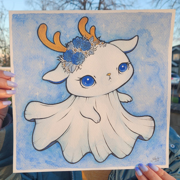 Watercolor painting on paper of a ghost with a cute rabbit or cat face. It has large blue anime style eyes, downturned ears and golden short antlers. It has a flower crown atop its head. Background is a soft blue watercolor.