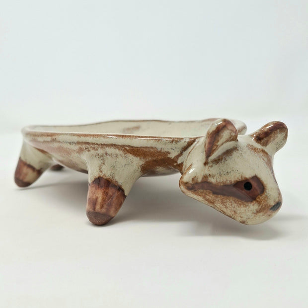 Ceramic vessel like a shallow plate with 4 legs and a raccoon head at the front of the plate.