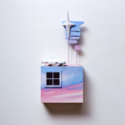 Small square wood panel painted like a pinkish purple sunset, with a sculpted window in the upper left. Atop of it are carved wooden sculptures: a retro style light blue car and a signpost with 5 different signs attached, no words, all a bluish purple sunset with one large sparkle.