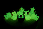 Small plastic capybara figures glowing in the dark.