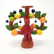 Ceramic sculpture designed as a Mexican tree of life sculpture, a brown 2 handled vessel with a red devil on the front. Around the handles are lemons, limes and oranges with leaves. Hanging off and protruding out via wire are decorative black balls.