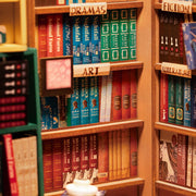 Close up of book store miniature room, with various shelves of categorized books.