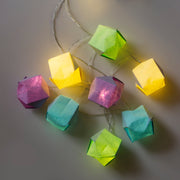 Product photo of 8 square origami paper boxes with fairy string lights attached in each and illuminating all of them.