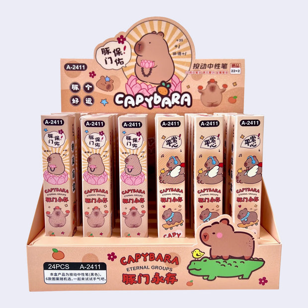 Display of 24 boxed pens, hiding the specific design within. Packaging has illustrations of cute capybaras.