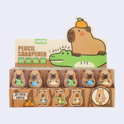 Display packaging for capybara shaped pencil sharpeners, 3 different designs. One holds a small crocodile, the other holds a turtle and final holds a duck.