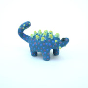 Sculpture of a blue stylized Ankylosaurus with neon green spikes and blue and purple polka dots on its body. It has a long tail and large shiny eyes.