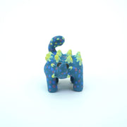 Sculpture of a blue stylized Ankylosaurus with neon green spikes and blue and purple polka dots on its body. It has a long tail and large shiny eyes.