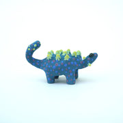 Sculpture of a blue stylized Ankylosaurus with neon green spikes and blue and purple polka dots on its body. It has a long tail and large shiny eyes.