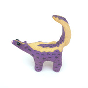 Ceramic sculpture of a purple skunk, done in a cartoon style with large bulbous black eyes and a very small, skinny head.