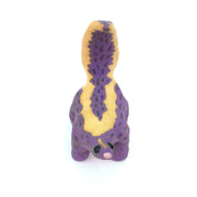 Ceramic sculpture of a purple skunk, done in a cartoon style with large bulbous black eyes and a very small, skinny head.