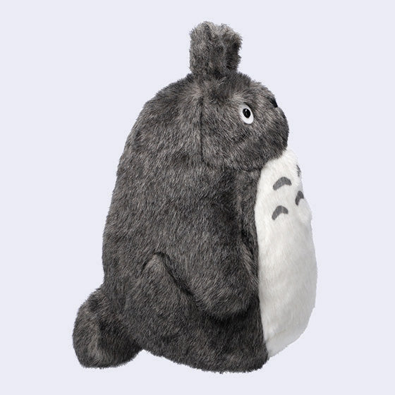 Dark gray Totoro plush, with a large white furry belly and whiskers. He has no mouth. Side view.