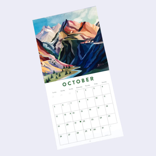 Staple bound calendar for the month of October, with one page being a full bleed illustration and the other having space for writing in each day. Illustration features several tall mountains, half cast in shadow and leading down to a winding river.