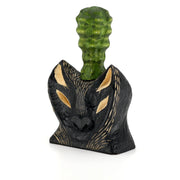 Whittled wooden sculpture of the bust of a bat/wolf creature, black with wooden accents. Coming out of its head is a green bumpy succulent cactus.