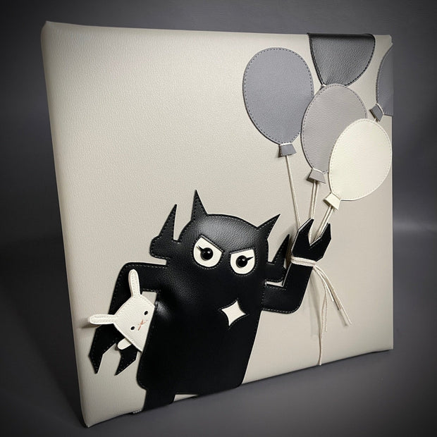 Greyscale pleather fabric art wrapped around a panel of a Big Boss Robot holding a bouquet of balloons in one hand and a small white bunny under the other arm.