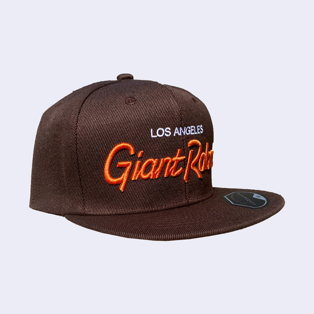 Flat billed cap, dark brown with white and orange stylized letters that say "Los Angeles Giant Robot" across the front.