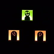 3 small wooden boxes with light fixtures in the back illuminating the cut out character in the center. One is a Kodama, two are No Face.