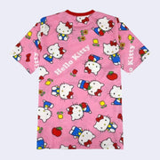 Pink t-shirt with a repeating all over pattern of Hello Kitty, standing and sitting with flowers and apples. "Hello Kitty" is written in white font throughout the pattern.