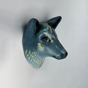 Ceramic sculpture of the bust of a blue wolf, with gold fur highlights and a serious, closed mouth expression.