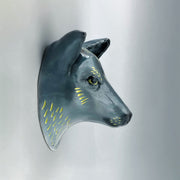 Ceramic sculpture of the bust of a blue wolf, with gold fur highlights and a serious, closed mouth expression.