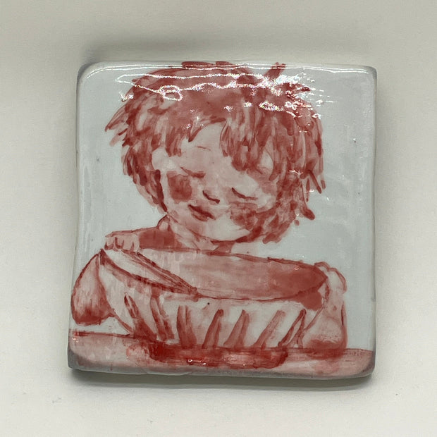 Ceramic tile with red illustration of a little girl with closed eye leaning over a large bowl with chopsticks.