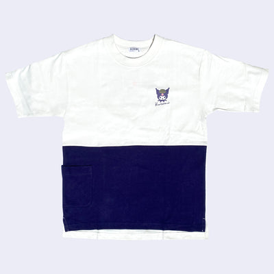 T-shirt that is color blocked: white on top half and dark purple on bottom half. Over the lapel is a small graphic of Kuromi's smiling face with a camping hat on.