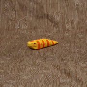 Wooden sculpture of a short and fat yellow snake with orange stripes and a red eye. Its body is akin to a banana slug.