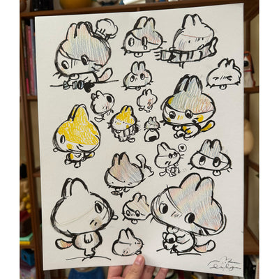 Paper full of doodles of a cartoon cat with a very large head and its tongue sticking out.