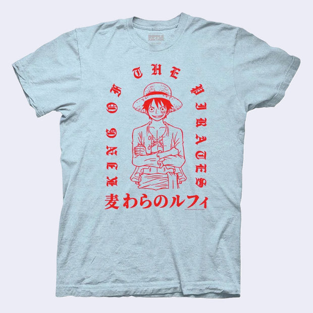 Light blue t-shirt with a red line art illustration of Luffy from One Piece standing with his arms crossed and a smile. Text around him says "King of the Pirates"