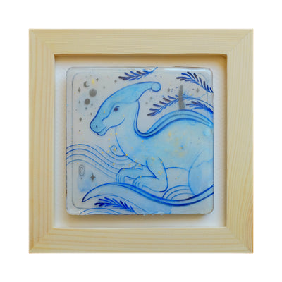 Blue line art illustration of a Parasaurolophus dinosaur with gold specks and blue leaves decorating the scene. Piece is in open face wood frame.