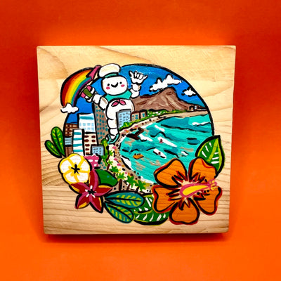 Painting on exposed wooden panel background of a Hawaiian beach-scape, with large buildings right up to the curved shore and a giant Stay Puft man stands behind them. Scene is enclosed in a circle with Hawaiian flowers framing it.