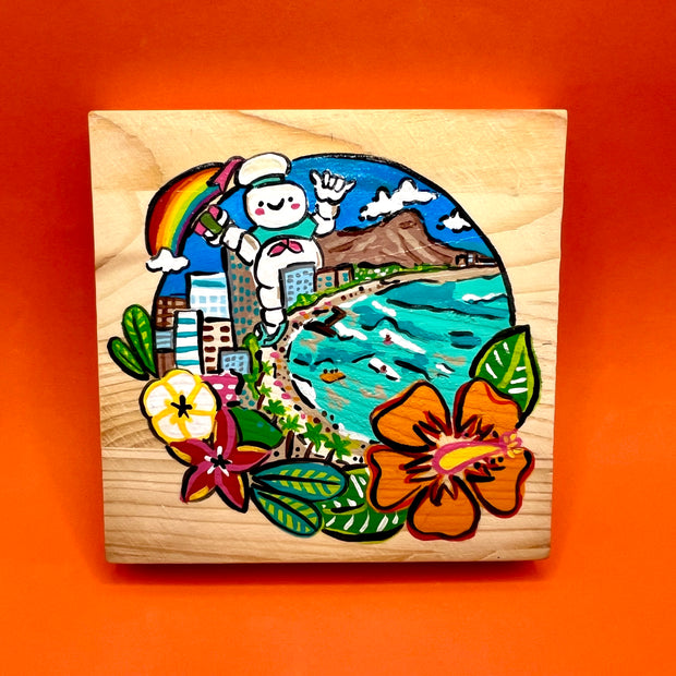 Painting on exposed wooden panel background of a Hawaiian beach-scape, with large buildings right up to the curved shore and a giant Stay Puft man stands behind them. Scene is enclosed in a circle with Hawaiian flowers framing it.