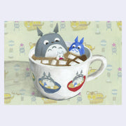 Painting of a white mug with hot chocolate within it and marshmallows. 3 Totoro characters sit within it - gray, blue and white descending in size. 