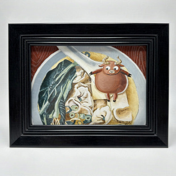 Painting of a bowl of ox tail soup, with a chubby cartoon ox sitting in the spoon. Piece is framed.