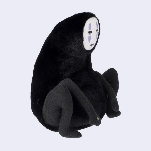 Rotund plush of No Face from Spirited Away hunched over and holding a single gold bead in its hand.