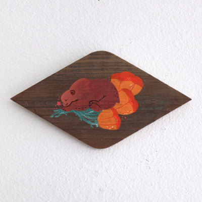 Painting on a diamond shaped piece of wood. Painting is of a cute brown bear sleeping on top of several orange poppy flowers.