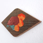 Painting on a diamond shaped piece of wood. Painting is of a cute brown bear sleeping on top of several orange poppy flowers.