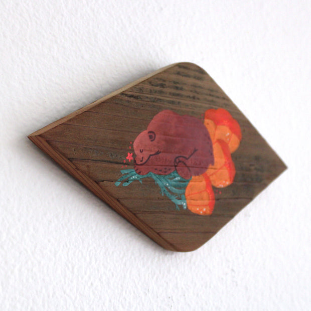 Painting on a diamond shaped piece of wood. Painting is of a cute brown bear sleeping on top of several orange poppy flowers.