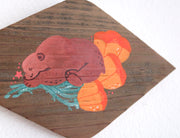 Painting on a diamond shaped piece of wood. Painting is of a cute brown bear sleeping on top of several orange poppy flowers.