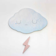 2 die cut wooden panels, one shapes like a cloud and painted light blue with a simple closed eye expression. Below, is a champagne pink colored lightning bolt.