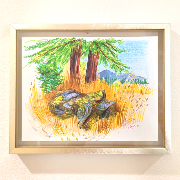 Vibrantly colored landscape painting of a colorful mossy tree stump amongst yellow tall grass. Behind are 2 pine trees and a far away mountain range. Piece is framed.