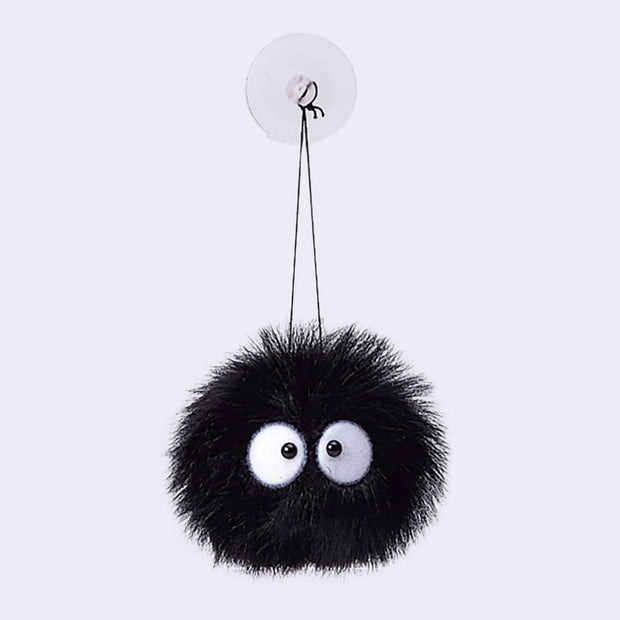 Round black ball of plushy fur with 2 eyeballs. It hangs from a black string from a suction cup.