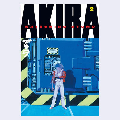 Cover for Akira Volume 2, featuring an illustration of an angry looking boy standing in front of a metal wall with several latches and various mechanical elements.