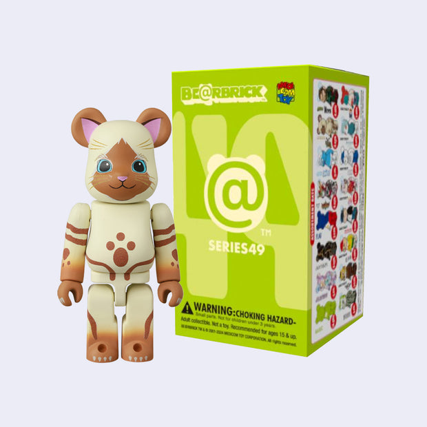 Figure shaped like bear but colored and designed to look like a brown cat with a tan body and striping. It stands on 2 legs in front of its product packaging. 