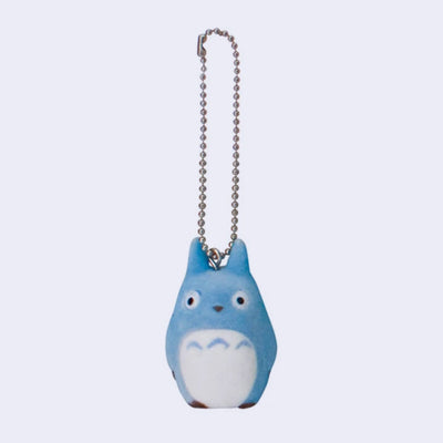 Small figure of a blue Totoro, with a slimmer body and no mouth. Its arms are at its side and a keychain is attached to the top of its head.