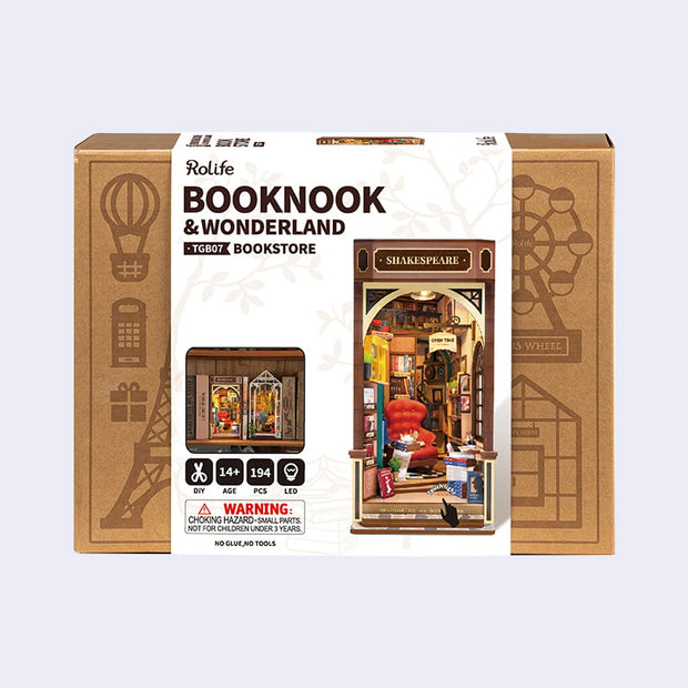 Product packaging for a 3D Booknook of a Shakespeare bookstore, with a big red arm chair and many rows of books around and behind. Contained within a rectangle that goes on a bookcase.