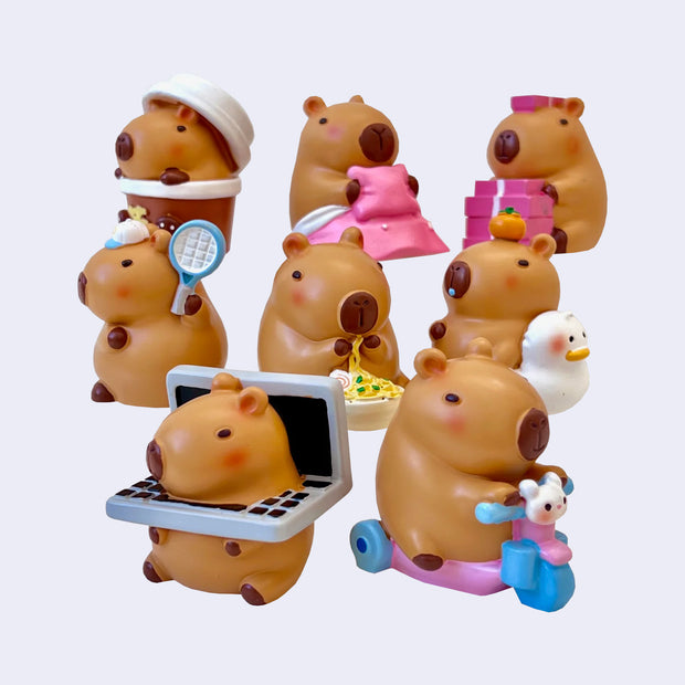 8 different designs of capybara figures, chubby and cute in a cartoon style. They all are engaging in different activities, such as eating, lounging, or playing around.