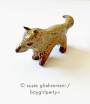 Small ceramic sculpture of a brown fox with a pointed snout, small ears and brown feet.