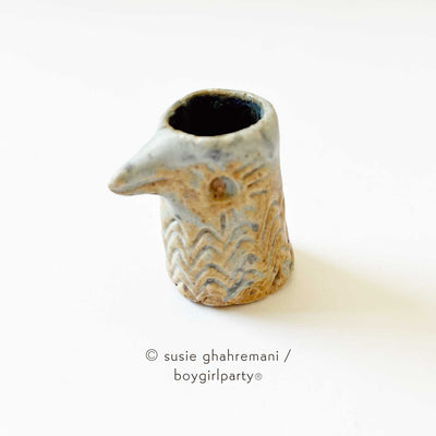 Small tan ceramic bird head with an opening for ink.