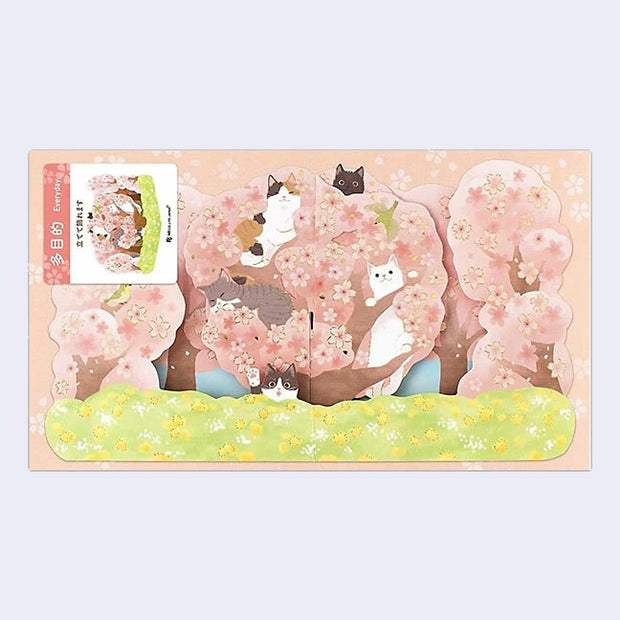 Folded card of a cherry blossom tree on green grass with many cute, different colored cats popping out from various branches and flower blossoms.