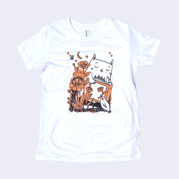 White children's t-shirt with an illustration of a cat reading a book with flowers and a small bird holding a flower in its beak.